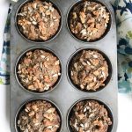 morning glory muffins in the tin, sprinkled with chopped walnuts and sunflower seeds