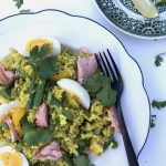 cauliflower kedgeree on a white plate with a side plate of lime wedges