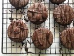 chocolate cookies drizzled with melted chocolate on a black cooling rack